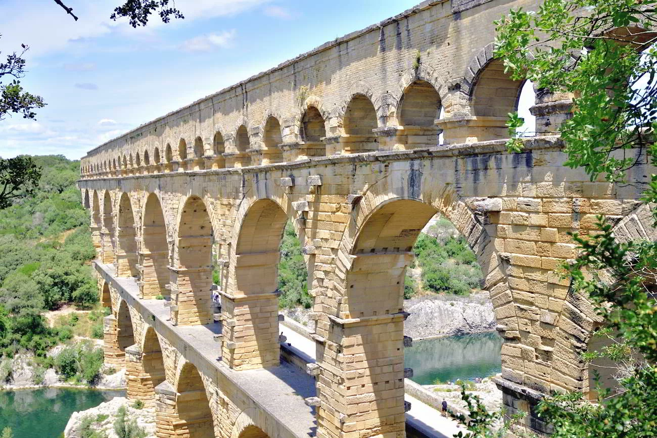 Le Pont du Gard, aqueduc romain en pierre blonde aux arches superpos&eacute;es, au-dessus du Gardon et de la garrigue